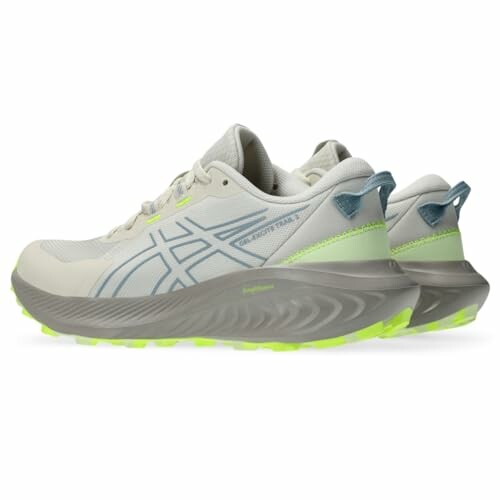 Pair of white and gray Asics trail running shoes with neon green soles.