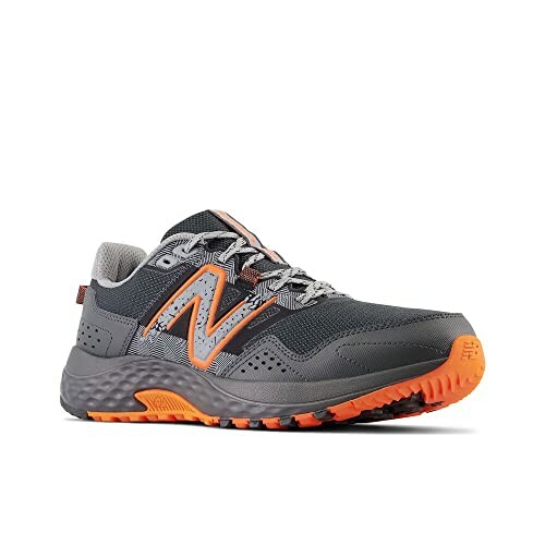 Grey and orange trail running shoe with rugged sole.