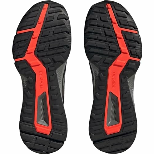 Black and red running shoe soles showing tread pattern