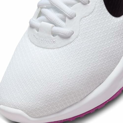 Close-up of a white sneaker with a pink sole.